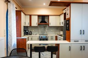 a kitchen with white cabinets and a table and chairs at Myrovolos Guesthouse in Apolpaina