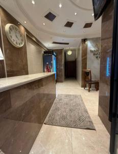 a lobby with a counter and a clock on the wall at فندق وفادة الزهراء in Baghdād