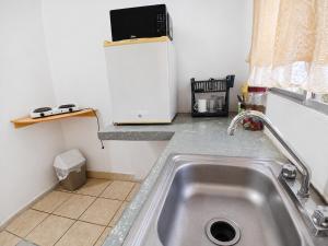 a kitchen with a sink and a refrigerator at Estudio Privado, WiFi, A 7 min de Palmerola in Comayagua