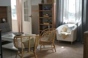 a living room with a table and two chairs and a table and a couch at Thula - Apartment in Villa Ambrosian in Trzebież