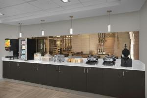 a kitchen with black cabinets and a white counter top at TownePlace Suites Des Moines Urbandale in Johnston