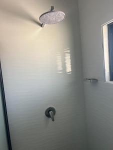 a bathroom with a shower with a light on the wall at Chaniche Executive Lodge in Ndola +10 photos