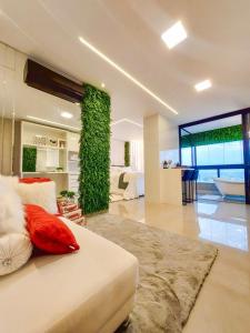 a room with a bed and a green wall at Vertigo Premium Studios in Campo Grande