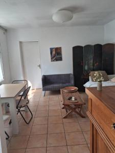 a living room with a couch and a table at Maison charmante bordée de bambous in Auffargis