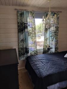 a bedroom with a bed and a window at Kaukuanjärven Kimallus in Kuloharju