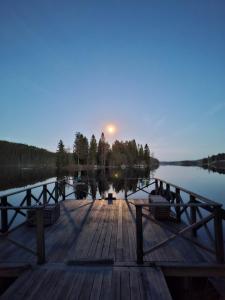 a dock with the sun rising over a lake at Ferienwohnung Käthe in Filipstad