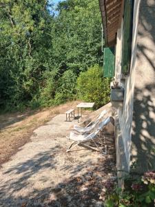 a porch of a house with a bench on the side at Maison charmante bordée de bambous in Auffargis