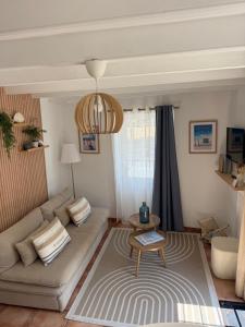 a living room with a couch and a table at Gîte le clos Normand in Saint-Jouin-Bruneval