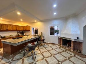 a kitchen with a fireplace and a counter top at Quiet house with pool in Aïn Harrouda +26 photos