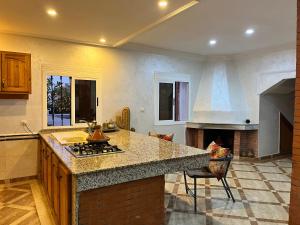 a kitchen with a counter and a stove top oven at Quiet house with pool in Aïn Harrouda