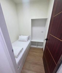 a small room with a bed and a door at Hotel Backpack BTS ปุณณวิถี in Bangkok