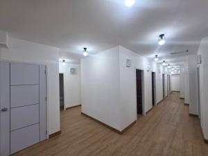 a large room with white walls and wooden floors at Hotel Backpack BTS ปุณณวิถี in Bangkok