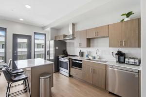a kitchen with stainless steel appliances and wooden cabinets at Illume 303 in Nashville