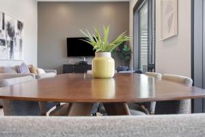 a dining room table with a yellow vase on it at Illume 303 in Nashville