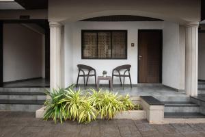 two chairs sitting on the front porch of a house at Treebo Five Elements with Swimming Pool in Lonavala