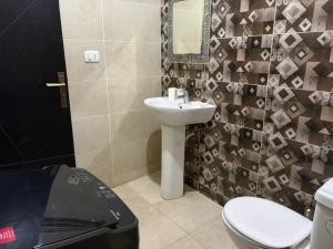 a bathroom with a sink and a toilet and a mirror at Pool view studio apartment, Aqua View Resort, North coast in El Alamein