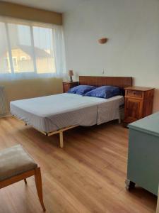 a bedroom with a bed and a wooden floor at les terrasses du Thouet in Parthenay