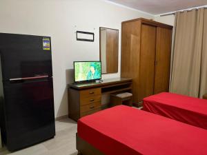 a room with a refrigerator and a tv on a dresser at Pool view studio apartment, Aqua View Resort, North coast in El Alamein