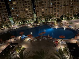 an overhead view of a large swimming pool at night at Pool view studio apartment, Aqua View Resort, North coast in El Alamein