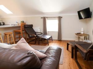 a living room with a leather couch and chairs at Pen Y Grisiau in Mold