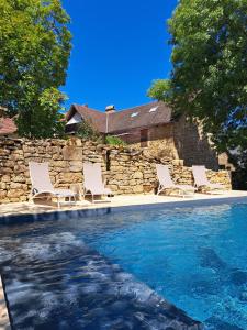 a group of chairs sitting next to a swimming pool at Instant Lot Maison pierre insolite Piscine Nature in Strenquels