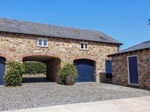 a brick building with two garage doors on it at Pen Y Grisiau in Mold