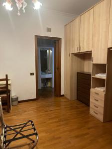 a kitchen with wooden floors and a chair in a room at La Maison Blanche in Borghesiana 