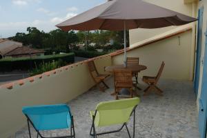 a patio with a table and chairs and an umbrella at Cabesthotes in Cabestany