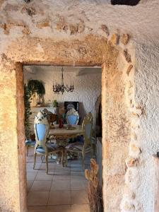 a dining room with a table and chairs in a stone wall at Le Château de Soleil in Saint-Pons-de-Mauchiens