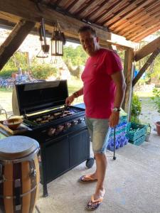 a man standing in front of a grill at French Fields Luxury Glamping Original Mongolian Yurt in Le-Vieux-Cérier