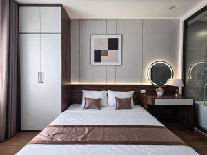 a bedroom with a large bed and a mirror at Tulip Building in Ðông Khê