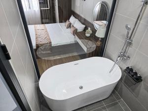 a bathroom with a white sink and a bed at Tulip Building in Ðông Khê