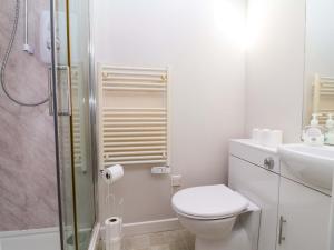 a white bathroom with a toilet and a sink at Ty Haf in Mold +26 photos