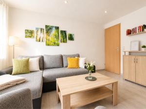a living room with a couch and a coffee table at Sonnendeck - Familienzeit im Wald in Dahlen