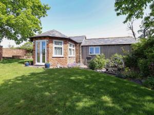 a brick house with a lawn in front of it at Ty Haf in Mold