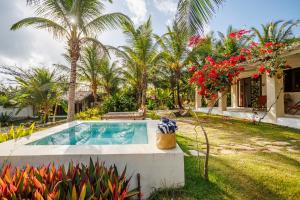 a villa with a swimming pool and palm trees at Preá Kite House in Prea