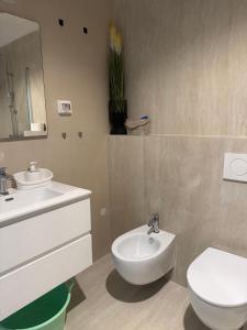 a bathroom with a white toilet and a sink at Baden Resort Bašanija, Umag-with Sea View, Parking and 300m from the beach in Bašanija +45 photos