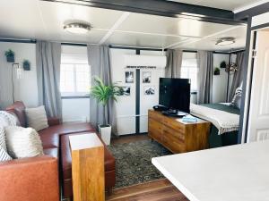 a living room with a couch and a tv at Box Villages Pecos in Pecos