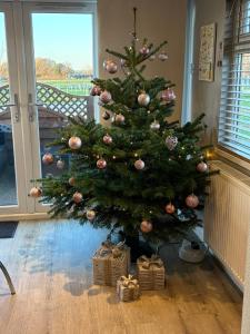 a christmas tree in a room with presents under it at The Lodge in Congleton
