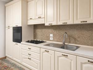 a kitchen with white cabinets and a sink at B&B ADU Civitavecchia in Civitavecchia