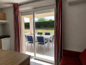 a dining room with a table and blue chairs at Soleiou in Salavas