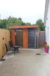 a backyard patio with a shed with a table and chairs at Rose Cottage Clonmel in Clonmel