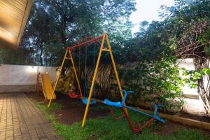 a playground with a swing set in a yard at Treebo Five Elements with Swimming Pool in Lonavala