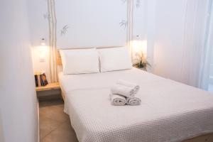 a bedroom with a white bed with towels on it at Anastasios' artwork apartment in Thessaloniki
