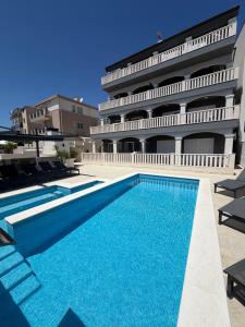 a swimming pool in front of a building at Villa Omazic in Trogir