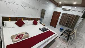 a bedroom with a large white bed with red pillows at Hotel DIVYA DARSHAN in Ujjain