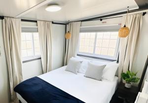 a bedroom with a bed and two windows at Box Villages Pecos in Pecos