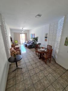 a living room with a couch and a table at Apartamento 3 Quartos, Churrasqueira, Vista Mar, Varanda, 5 min da praia in Guarapari