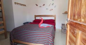 a bedroom with a bed with a pink swan on it at Casa MACONDO BEACH HOUSE in Rincón