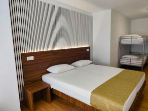a bedroom with a large bed with a wooden headboard at Hotel Amstar Simeria in Simeria